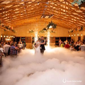 Una novia y un novio bailando en un piso de nubes en Inyala Game Lodge, en Ventersdorp
