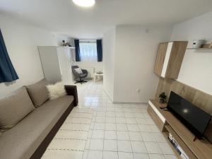 a living room with a couch and a flat screen tv at Chill Apartman in Balatonfüred