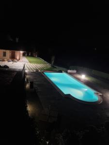 ein großer blauer Pool in der Nacht in der Unterkunft Ca' del magu in San Michele Mondovì