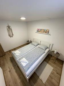 a bedroom with a bed and a painting on the wall at Chill Apartman in Balatonfüred