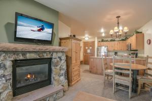 a living room with a fireplace and a tv at Expedition Station 8622 in Keystone