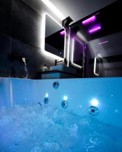 łazienka z wanną wypełnioną błękitną wodą w obiekcie OPALENSIA w mieście Thuin