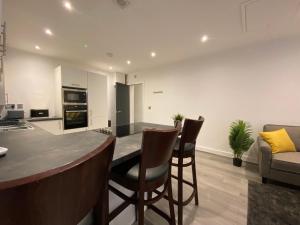 a kitchen and living room with a table and chairs at Modern 3 bedroom apartment close to the city centre in Liverpool