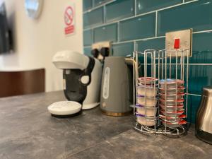 a counter with a coffee maker and cups on it at Modern 3 bedroom apartment close to the city centre in Liverpool