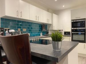 a kitchen with white cabinets and blue tile at Modern 3 bedroom apartment close to the city centre in Liverpool