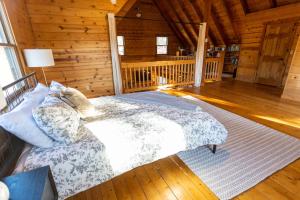 um quarto com uma cama num chalé de madeira em Tranquility on White Tail Road em Deadwood