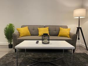 uma sala de estar com um sofá com almofadas amarelas em Modern 3 bedroom apartment close to the city centre em Liverpool