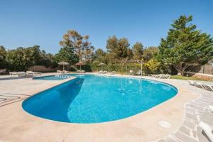 a large swimming pool with chairs around it at Serena Sol Apartments - Adults Only - Over 12 in Cala Serena