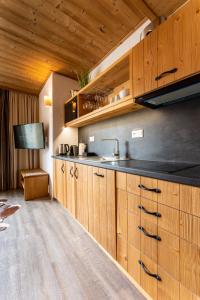 eine Küche mit Holzschränken und einem Waschbecken in der Unterkunft Apartmán SAFFRON Chalet JASNÁ in Demänovská Dolina