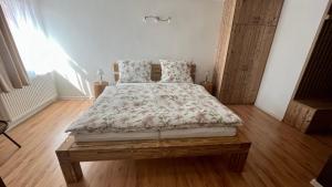 Cama en habitación con suelo de madera en Apartmány Stanos Bikes en Revúca