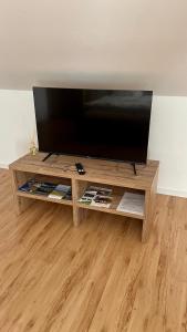 a flat screen tv sitting on top of a wooden entertainment center at Apartmány Stanos Bikes in Revúca