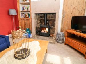 a living room with a fireplace and a tv at The Old Stables in Matlock