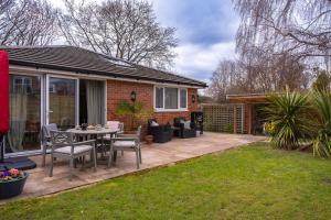 a patio with a table and chairs in a yard at The Nest in Brockenhurst