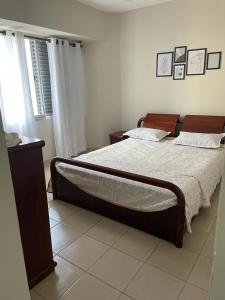 um quarto com uma cama grande e uma janela em Apartamento Guarujá Pitangueiras 50 metros Praia/3 Dormitórios/Vista do Mar, Sol da manhã no Guarujá