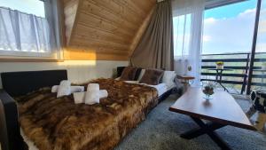 ein Schlafzimmer mit einem großen Bett und einem Tisch in der Unterkunft Pokoje Kubikowe in Ząb