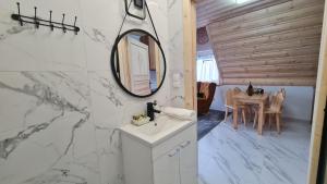 a bathroom with a sink and a mirror and a table at Pokoje Kubikowe in Ząb