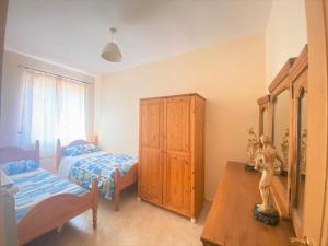 een slaapkamer met 2 bedden en een houten kast bij Suite 24 Ercolano in Ercolano