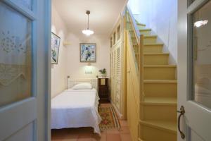 Un pequeño dormitorio con una cama y una escalera en Triantaros Artful Houses, en Triandáros