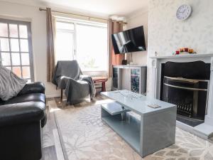 a living room with a couch and a fireplace at Bungalow by the Sea in Cleveleys
