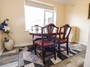 a dining room table with two chairs and a window at Bungalow by the Sea in Cleveleys