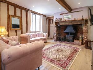 sala de estar con 2 sofás y chimenea en The Bridewell en Woodbridge