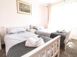 a bedroom with two beds with towels on a bench at Bungalow by the Sea in Cleveleys