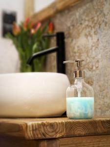 a soap dispenser sitting on a counter next to a sink at DomkiTomki in Biskupice