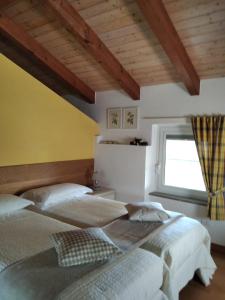 2 Betten in einem Schlafzimmer mit Fenster in der Unterkunft Casa Via Castelmonte in Cividale del Friuli
