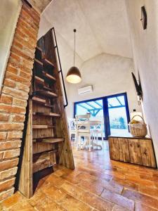 Pokój z ceglaną ścianą i drewnianymi schodami w obiekcie DomkiTomki w mieście Biskupice