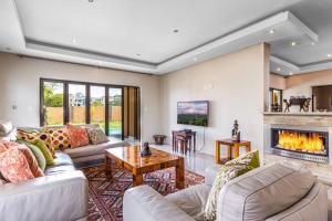 a living room with two couches and a fireplace at Pearl House in Centurion