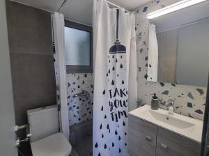 La salle de bains est pourvue d'un rideau de douche, de toilettes et d'un lavabo. dans l'établissement Tiffany's apartments -2' walk from Metro, à Athènes