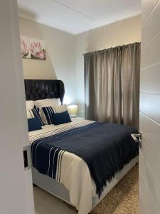um quarto com uma cama grande e uma janela em Lovely Cozy Apartment em Midrand