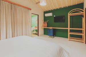 een slaapkamer met een bed en een groene muur bij Pousada Vilagoa in Coqueiro Sêco