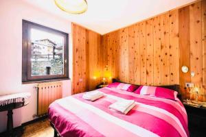een slaapkamer met een groot bed en houten wanden bij Caldo appartamento vicino a Bormio + wifi + garage in Santa Caterina Valfurva