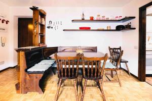 een eetkamer met een tafel en een piano bij Caldo appartamento vicino a Bormio + wifi + garage in Santa Caterina Valfurva