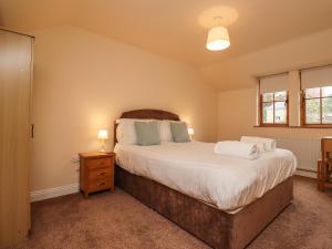 a bedroom with a large bed and two windows at Stewart House in Wooler