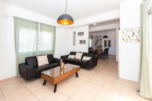 a living room with two black couches and a coffee table at Villa White Star - 100m from Serena Beach in Protaras +28 photos
