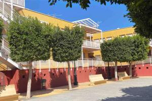 a row of trees in front of a building at Precioso apartamento en Benahadux a 9 km Almería in Benahadux