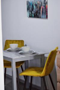 a dining room table with two chairs and a table with two bowls at Cozy rooms at the old Venetian Harbor, Chania Town in Chania Town