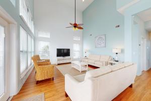 a living room with a white couch and a tv at Serenity On The Bay in Fairhope