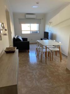 sala de estar con mesa y sofá en Regia Apartamentos Posadas en Posadas