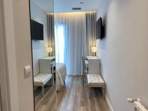 Habitación de hotel con espejo, cama y silla en A PONTEVELLA Alojamiento Boutique, Sobradelo en Sobradelo