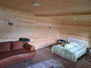 een kamer met een bank en een bed in een hut bij Cabanele Valea Bradului in Izvoru Mureşului