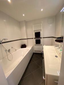 a white bathroom with a tub and a sink at Edelweiss - fewo-badhindelang in Bad Hindelang +9 photos
