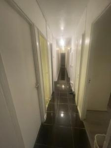 a hallway with a long corridor with white walls at Xtra large 1 bedroom London Flat in Woolwich