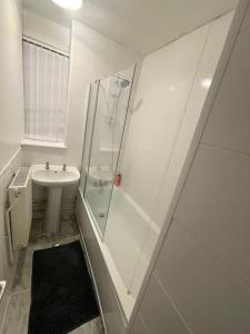 a white bathroom with a shower and a sink at Xtra large 1 bedroom London Flat in Woolwich