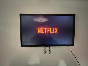 a television hanging on a wall with the words netflix at Xtra large 1 bedroom London Flat in Woolwich