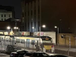 un treno bianco in una strada di città di notte di Xtra large 1 bedroom London Flat a Woolwich