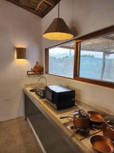 a kitchen counter with a microwave and a window at Exclusiva Casita frente al mar in Barra de Potosi +20 photos