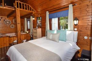 a bedroom with a large bed in a wooden room at בקתה בתמרים in Moshav Ramot